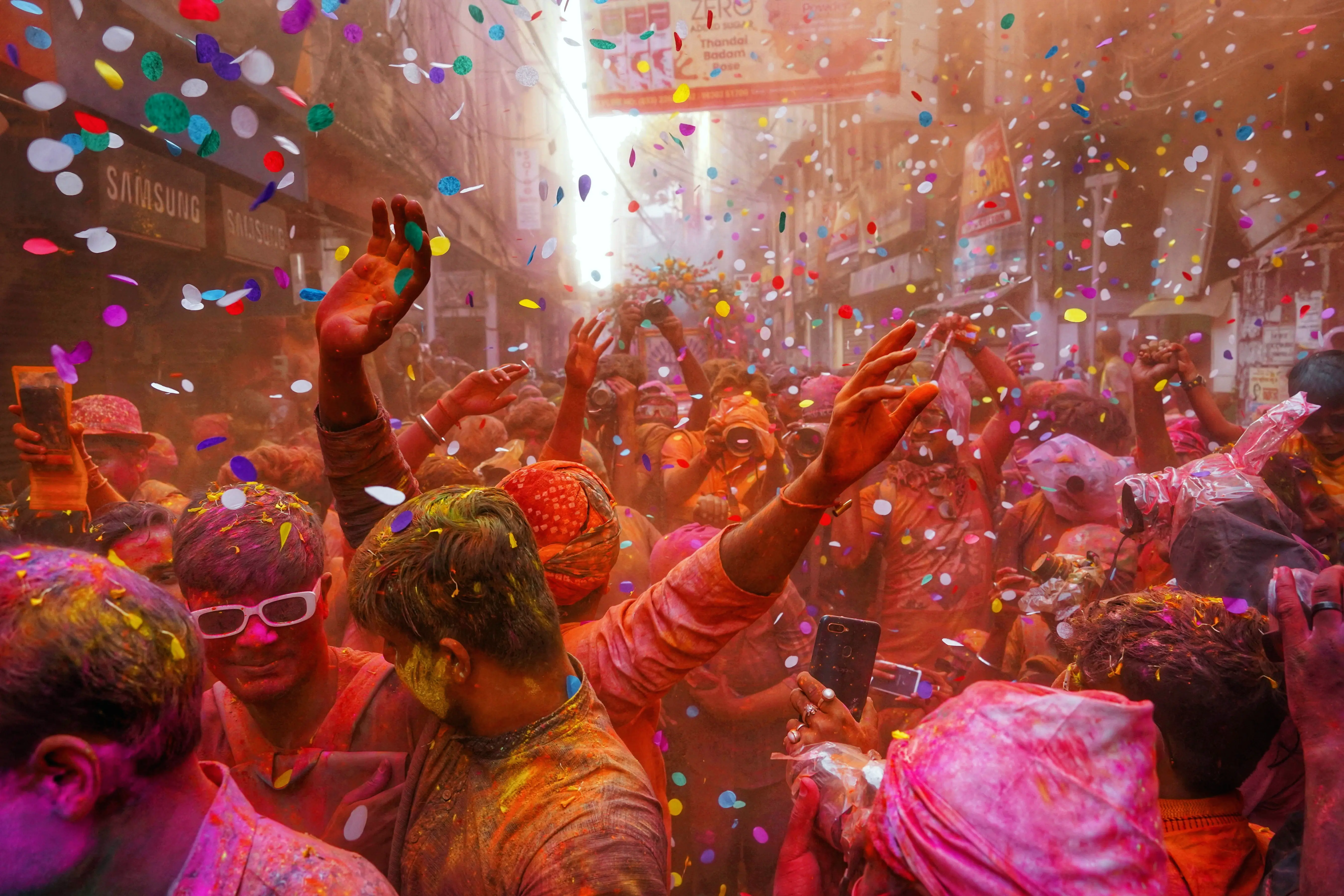 Holi festival crowd with raised arms.